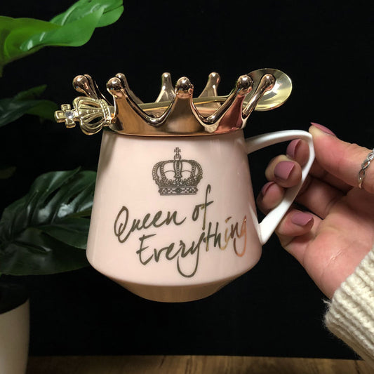 Mug with gold crown design and 'Queen of Everything' text, held by a hand.